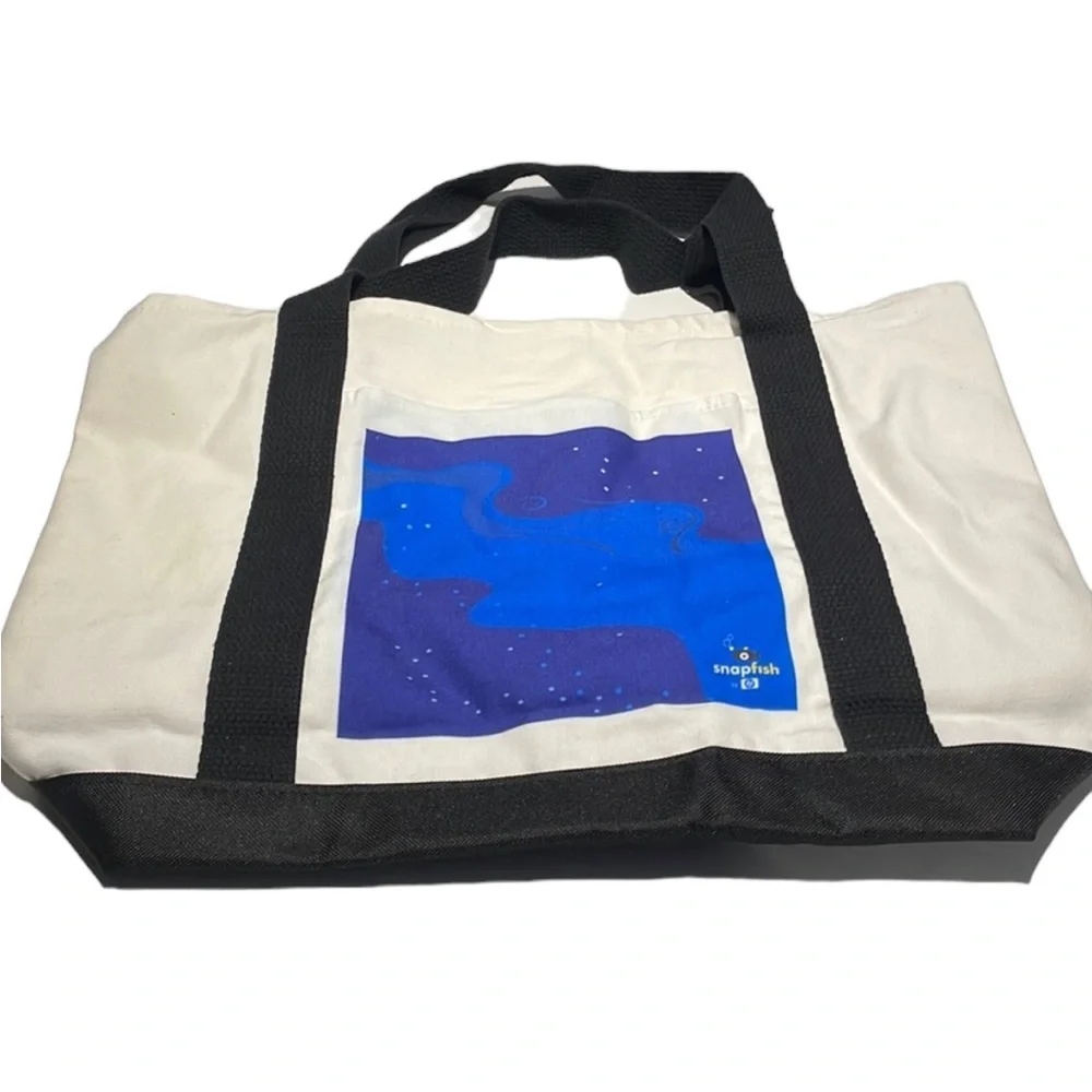 Canvas tote with black straps. Outside pocket with Snapfish logo. NWOT
